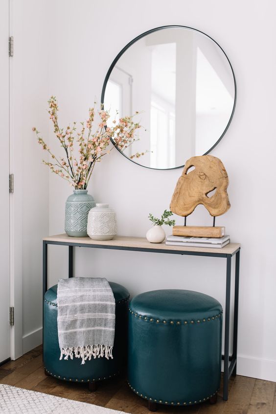 Narrow entry table with blue leather ottomons and wooden driftwood sculpture