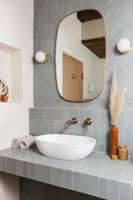 White Vessel sink rising out of pale blue fireclay tile counter