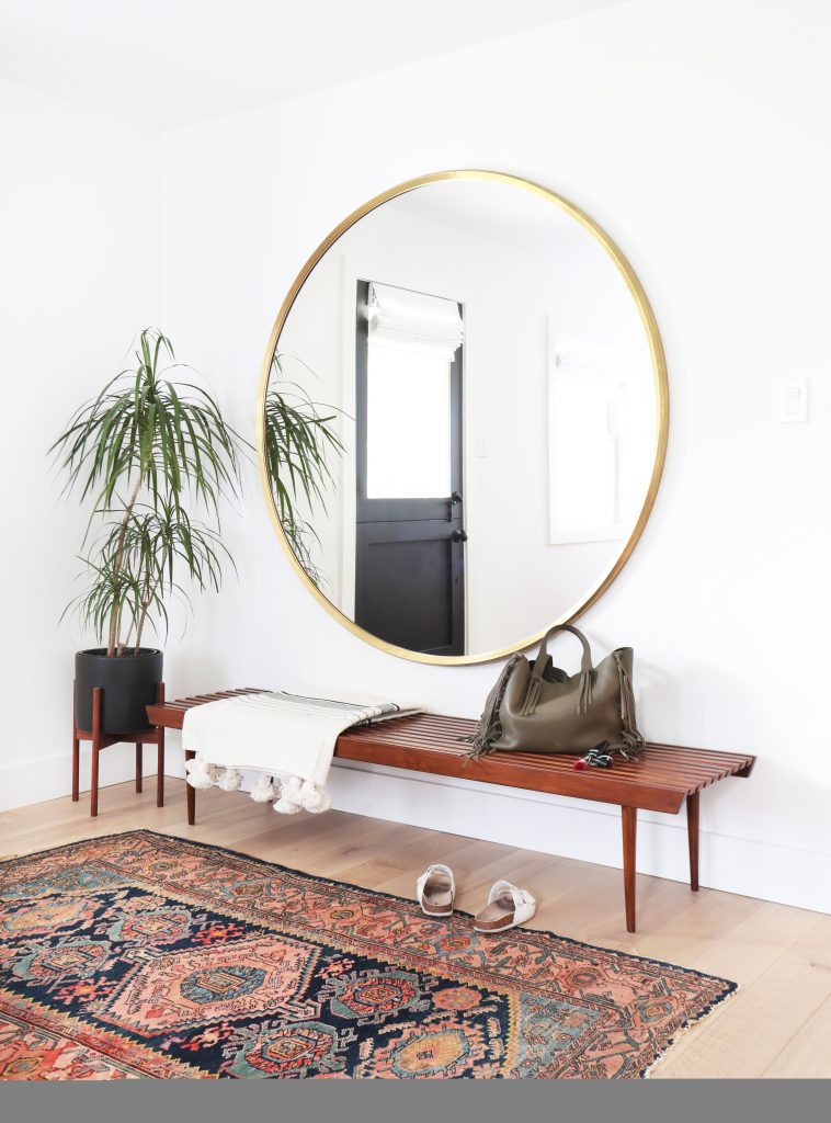 oversized round mirror, vintage rug, amber interiors, bench