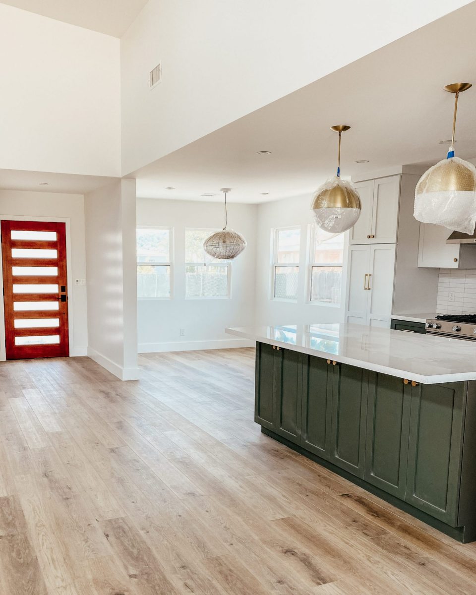 The open kitchen space with kitchen island, breakfast nook, and front door in view 