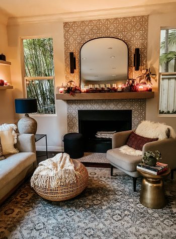 The living room is moody, lit with glowing candles on the mantle and shelves