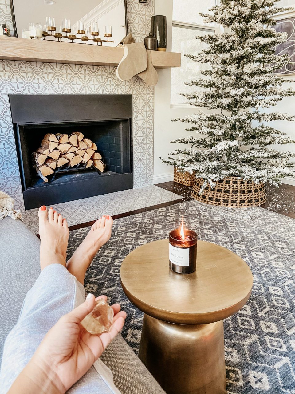 Anita holds a crystal in hand sitting beside the christmas tree