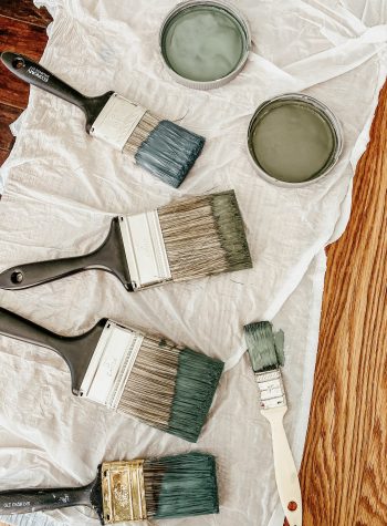 Paintbrushes dipped in varying shades of muted green