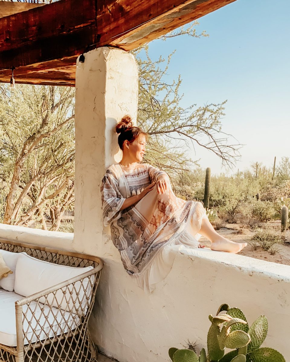 Anita sits on a pony wall, looking out onto the desert plains