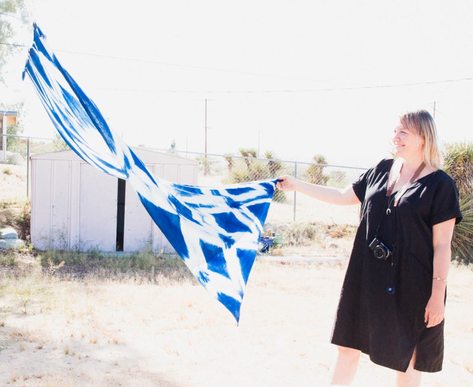 Lindsay Hollinger holding up shibori dye textile