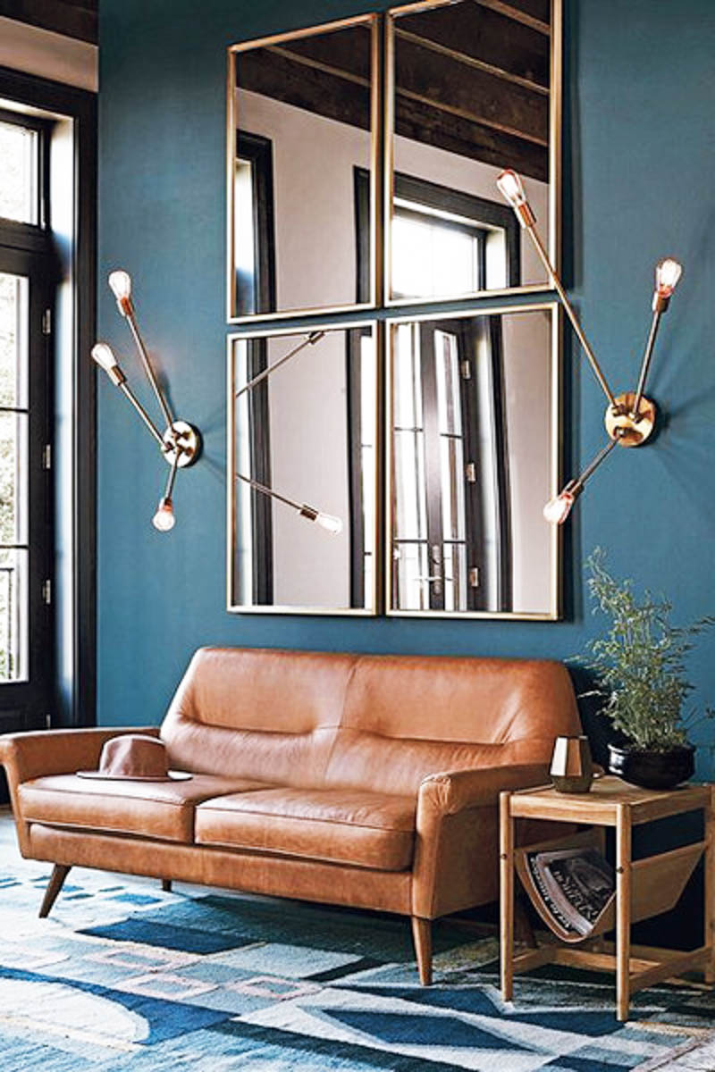 dark walls living room mid century modern design brass lights leather couch 