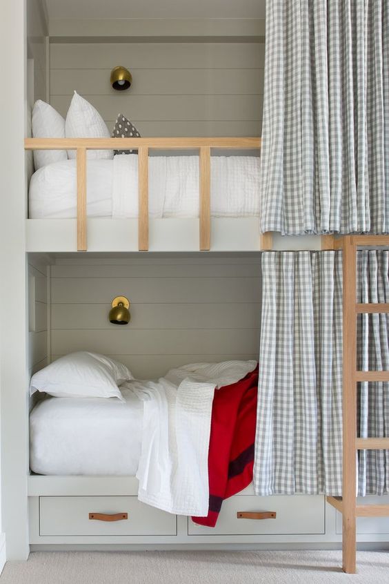 Built in bunk beds in a khaki color with shiplap + leather hardware on the drawers + brass sconces. We love the option for more privacy with the curtain pullback | ABD Studio