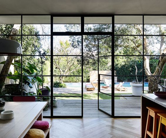 Black framed windows from kitchen to back yard