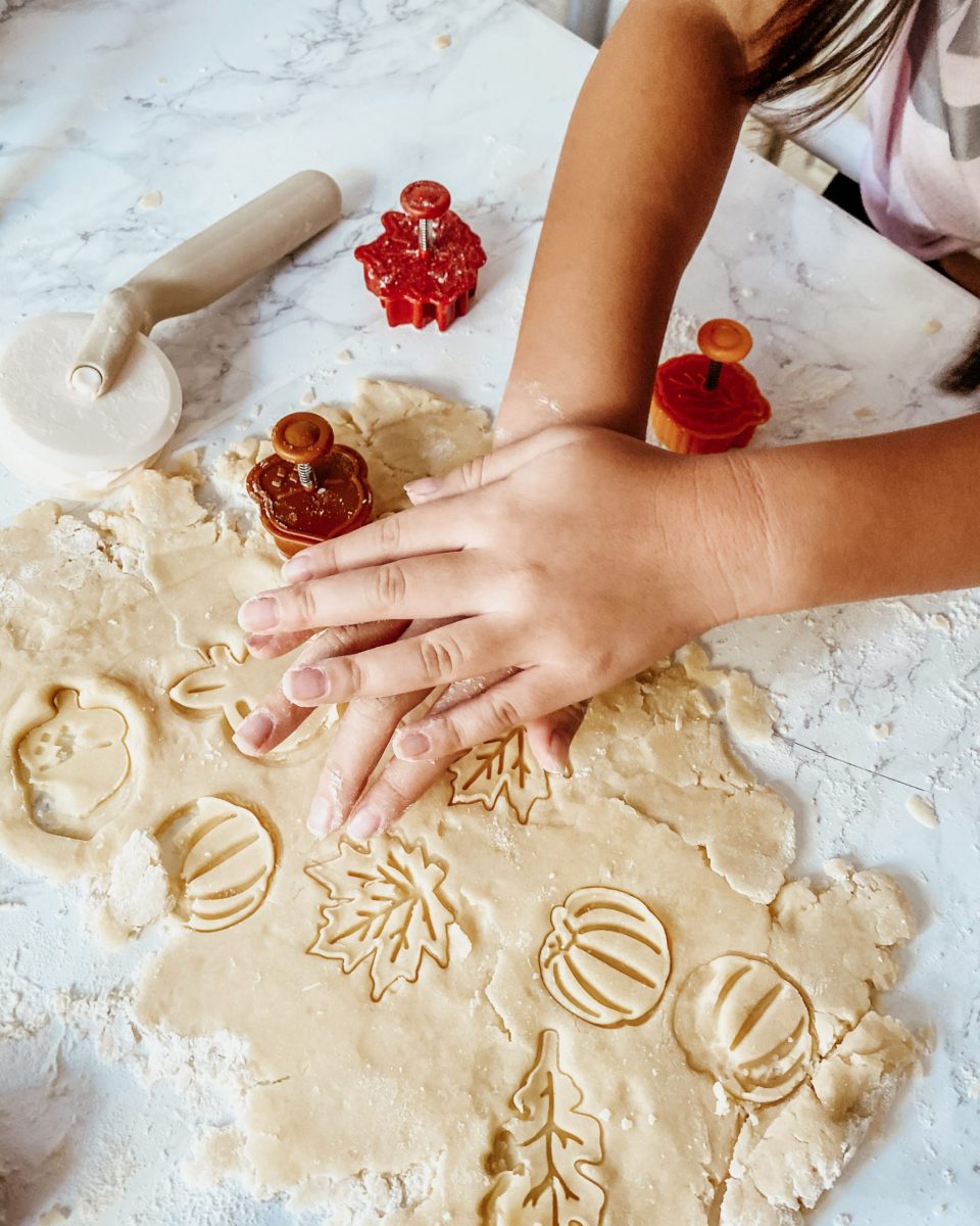 Natalie's teeny hands cutting fall shapes (leaves, pumpkins) into pie dough