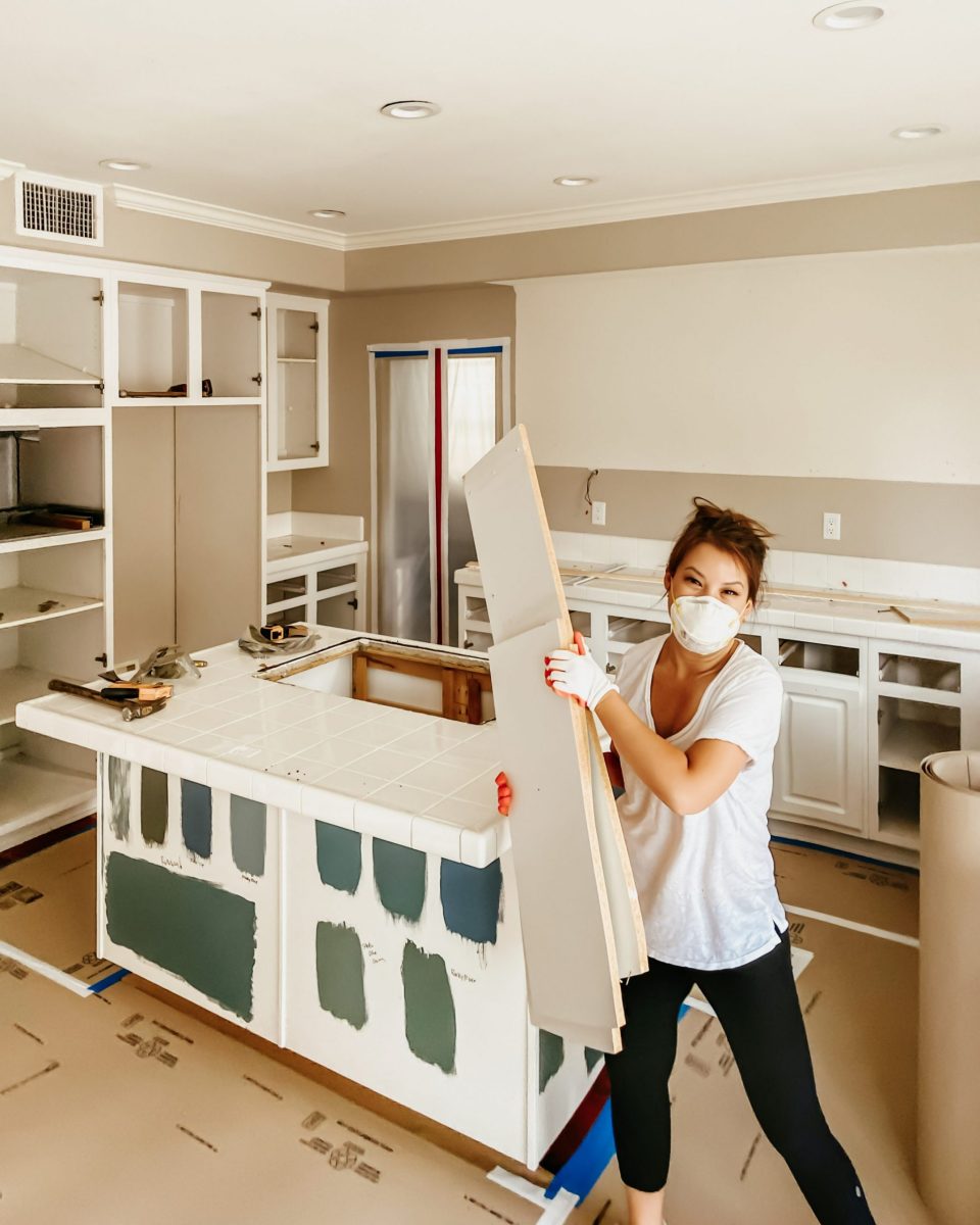 Anita demoing the kitchen, with blue and green swatches painted on the kitchen island