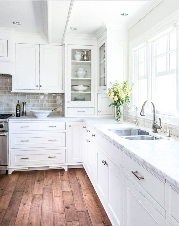 The Ultimate guide to Laminate Flooring // white kitchen cabinets grey subway tile laminate wood flooring 